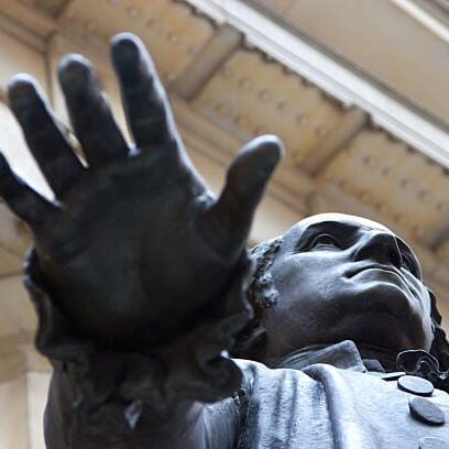 A statue of a man with his hand up in the air.